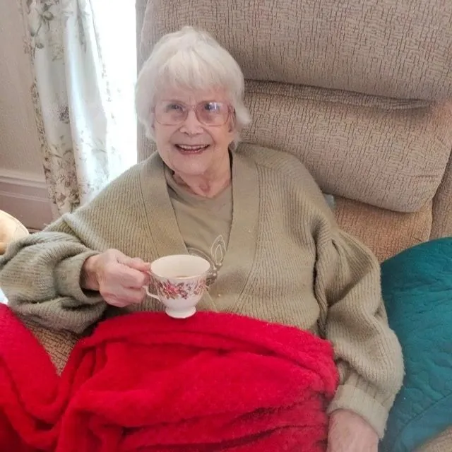 Smiling woman sat drinking tea