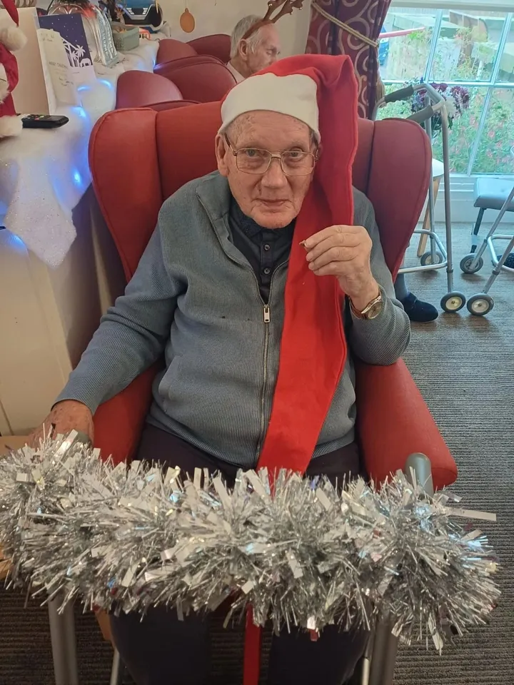 A man wears a Christmas hat and scarf