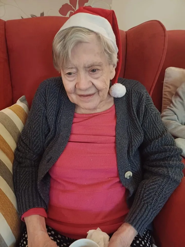 A woman enjoying wearing a Christmas hat