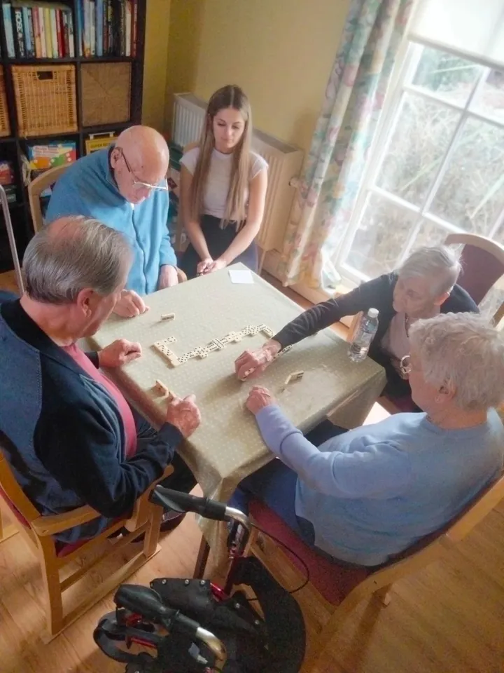 Four people playing dominos together