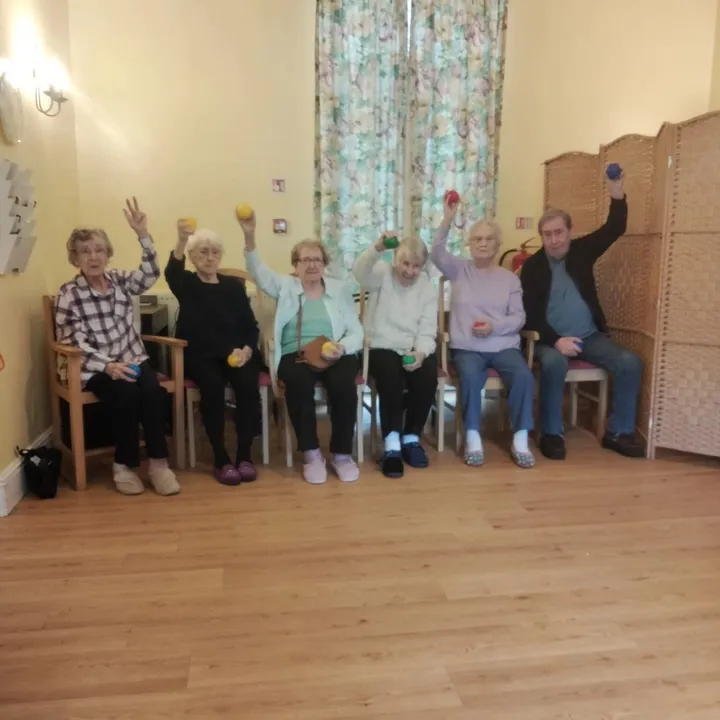 A group of seated people are waving