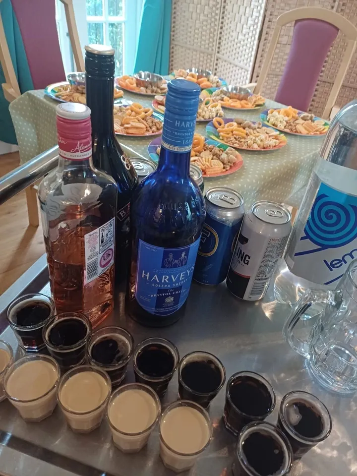 A trolley with several bottles of drinks and glasses